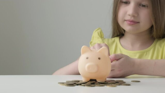 Provident economical little girl child put coins into piggy bank saving for future needs. Happy smart small 9s teen kid make donation contribution in piggybank. Investment concept. Children's savings