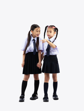 Back to school. Asian junior international school students in uniform posing full length on white background.