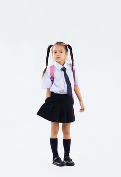 Back to school, junior school student in british uniform full length on white background.
