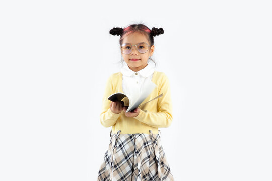 Junior school asian student with book posing on white background.