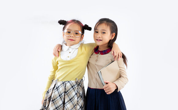 Back to school. Two little Asian girl students posing on white background.
