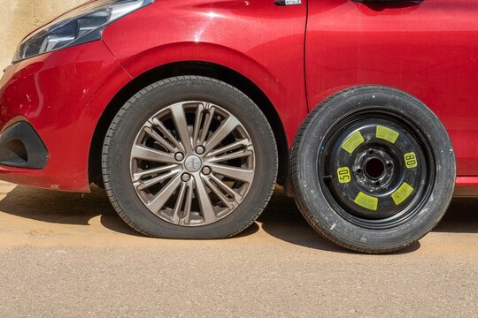 Flat tire of a red Peugeot 208 car