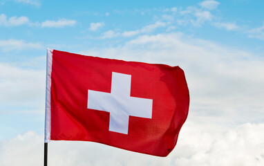 Obraz premium Swiss flag waving against sky