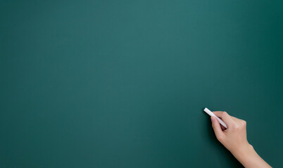 Woman hand writing by chalk on blackboard
