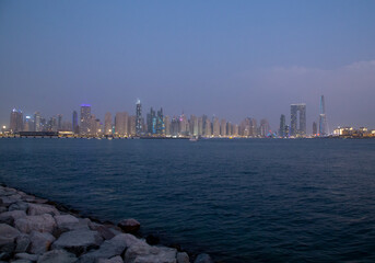 Dubai city skyline at night with water in front with grain out of focus