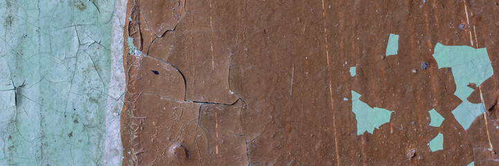 Peeling paint on the wall. Panorama of a concrete wall with old cracked flaking paint. Weathered...
