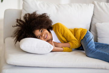 Relaxed african american child lying on couch at home