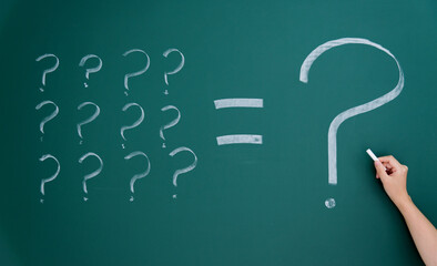 Question marks written on blackboard