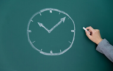 Chalk drawing clock on blackboard