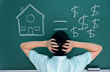 Man in front of drawing house and money on blackboard