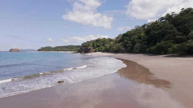 Wide angle establishing shot of an empty, tropical beach on the lush and untouched pacific coast of central America
