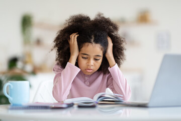 Exhausted african american child schooler doing homework