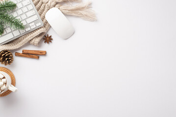Winter mood concept. Top view photo of workstation keyboard computer mouse mug of cocoa pine cone spruce branch cinnamon sticks anise and cozy knitted plaid on isolated white background with copyspace