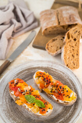 Homemade vegetable bruschetta on a handmade ceramic plate in warm colors, horizontal orientation, top view