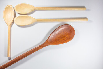 Close up and top view of wooden spoons on white background.
