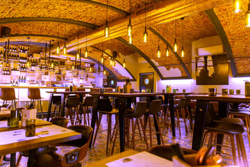 Interior of cozy modern restaurant with a bar counter and lamp lighting