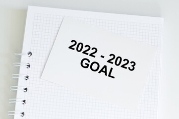 Blknot with a card on which is written 2022 - 2023 goal
