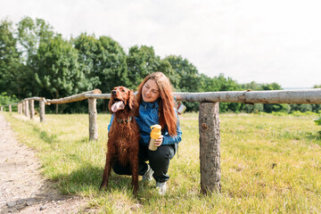 Woman and her friend dog on country road background. Human and a dog. Concept of solitude and...