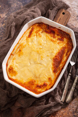 Fresh lasagna with meat and tomato sauce baked in the oven in a ceramic dish.