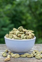 Cardamom Pods or Cardamon in  a White Bowl on  Wooden Background with Selective Focus