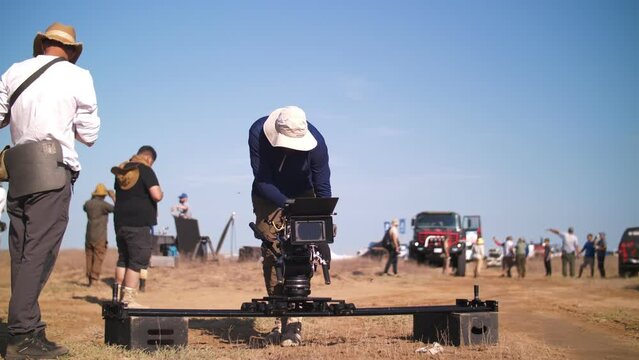 Filming in the steppe. The operator moves the video camera along the slider. Film crew