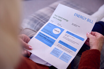 Close Up Of Senior Woman At Home Looking At USA Energy Bill During Cost Of Living Energy Crisis