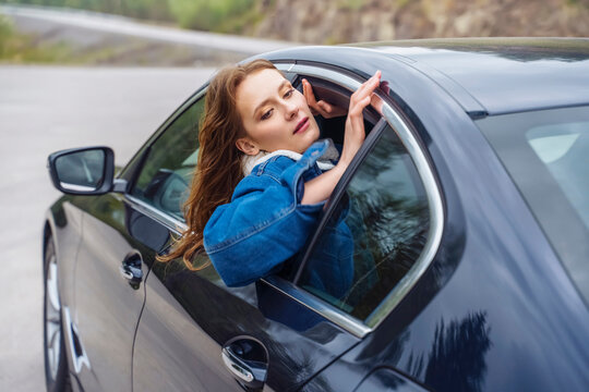 Woman In Discomfort Girl In Car Window. Car Trip. Autumn, Road, She Is Wearing A Denim Jacket