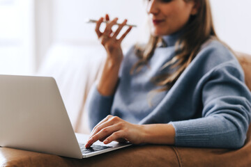 Businesswoman making a phone call while working on a laptop