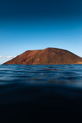 Montagna roja de Isla de Lobos en Fuerteventura al atardecer desde el mar