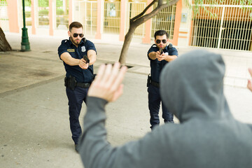 Angry police officers arresting a young man criminal