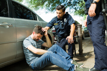 Cops helping an injured man after a car crash