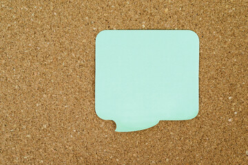 Single yellow sticky post note on corkboard