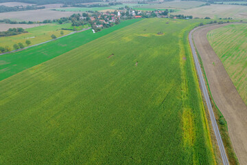 Panoramic view of the green field and the village near the railway.