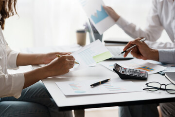 Business people pointing to graph and chart to analyze market, sale, balance sheet, account, net profit data to see the growth of the organization and to develop product.