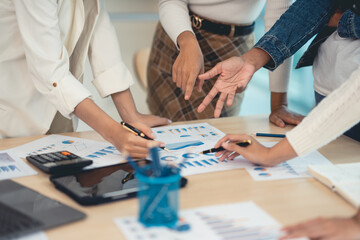 Business people pointing to graph and chart to analyze market, sale, balance sheet, account, net profit data to see the growth of the organization and to develop product.