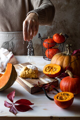 Woman's hand sprinkling flour on dough. Fall autumn pumpkin gnocchi cooking process