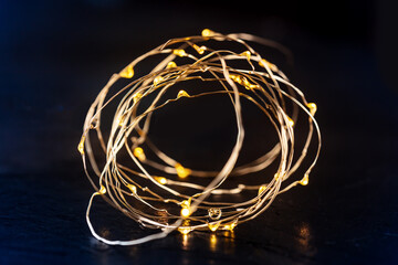 Fairy lights led garland coil, blurred. Christmas atmosphere concept on black