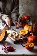 Woman's hand cutting dough. Fall autumn pumpkin gnocchi cooking process