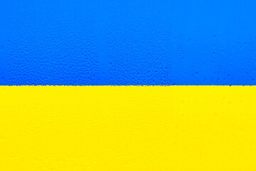 National flag of Ukraine. Yellow-blue flag on the texture of the condensation of water drops, natural texture. Symbol, poster, banner of the national flag