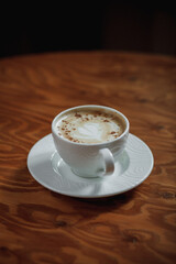 cup of cappuccino coffee on wooden table