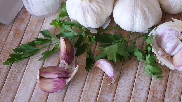 Parsley and garlic on wooden table. Preparing food concept.
