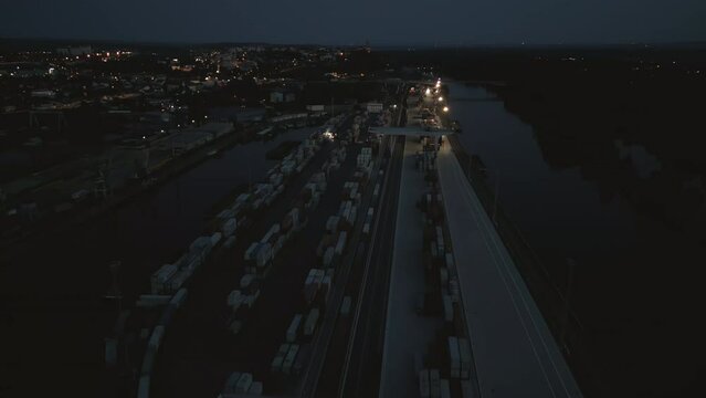 Aerial view of the dimly lit Melnik river port with containers and spreaders working the night shift