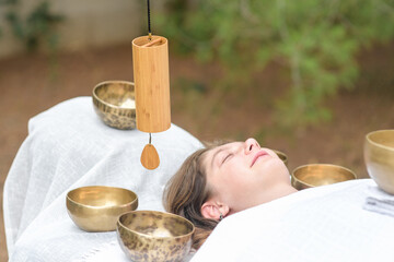 Male hand holding a bamboo Koshi chime musical instrument on sound healing therapy with tibetan...