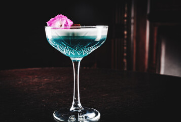 cocktail with gin, lime juice and soda on rustic wooden table on dark background