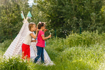 Adorable little girls having fun playing outdoors on summer day