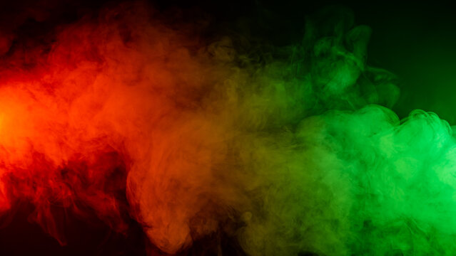 Red Green Smoke On A Black Background. 