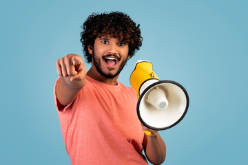 Handsome eastern guy shouting through loudspeaker and gesturing