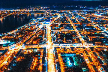 Aerial view of the night city in winter. Movement of cars on lighted streets and intersections