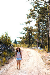 Obraz premium A woman with a backpack and a straw hat on a mountain path