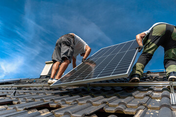 Men worker installing solar photovoltaic panels on roof, alternative energy, saving resources and...
